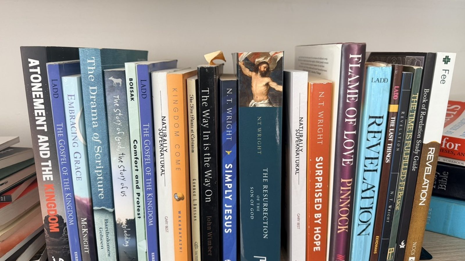 A shelf of Denvil's books, spines out: Ladd, McKnight, N. T. Wright, Boesak and a run of titles on the kingdom and Revelation.