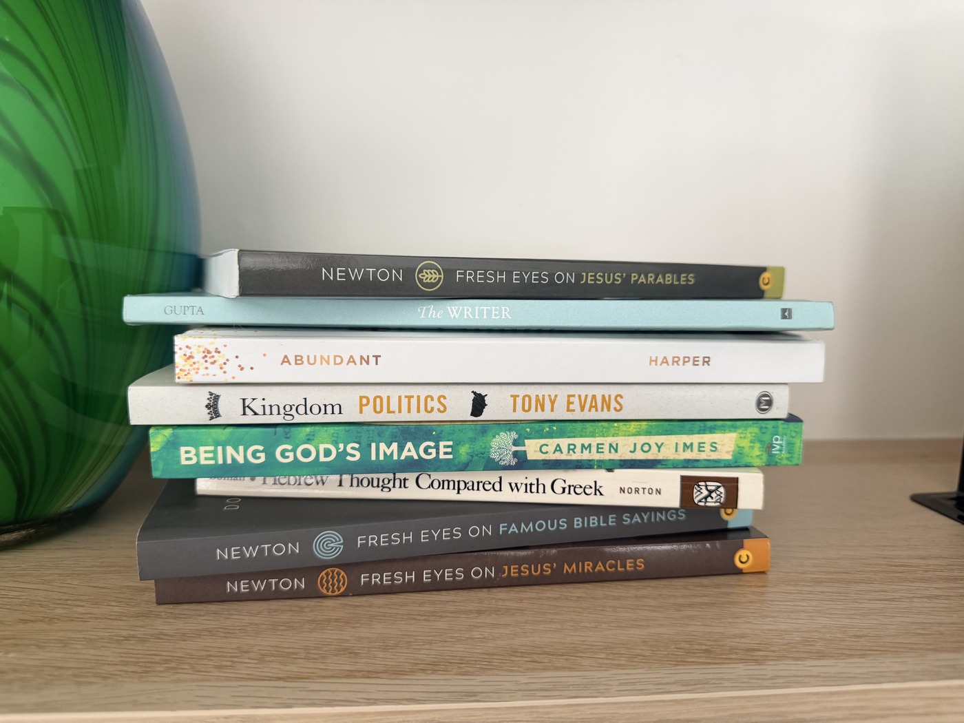A stack of Denvil's books on a table, spines out.